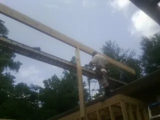 Carpenter setting a ridge beam over a new addition frame — Ice Dam Removal by Roofing Brothers in Maxatawny