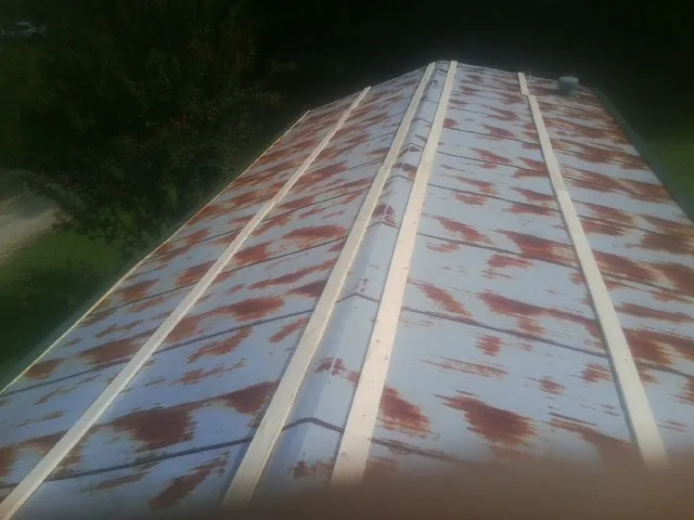 Rusted metal roof panels with new wood purlins before replacement — Storm Damage Roof Repair in Maxatawny by Roofing Brothers