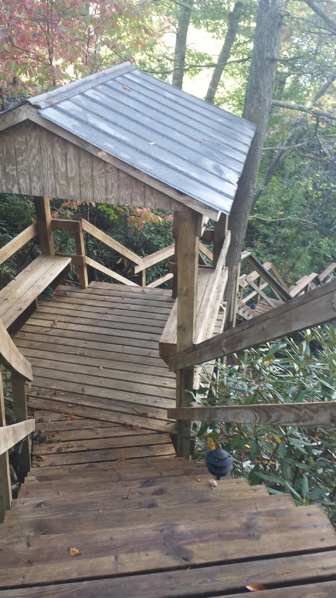 Metal roofed shelter over wooden steps on a wooded walkway — Skylight Repair & Installation work by our crew in Maxatawny