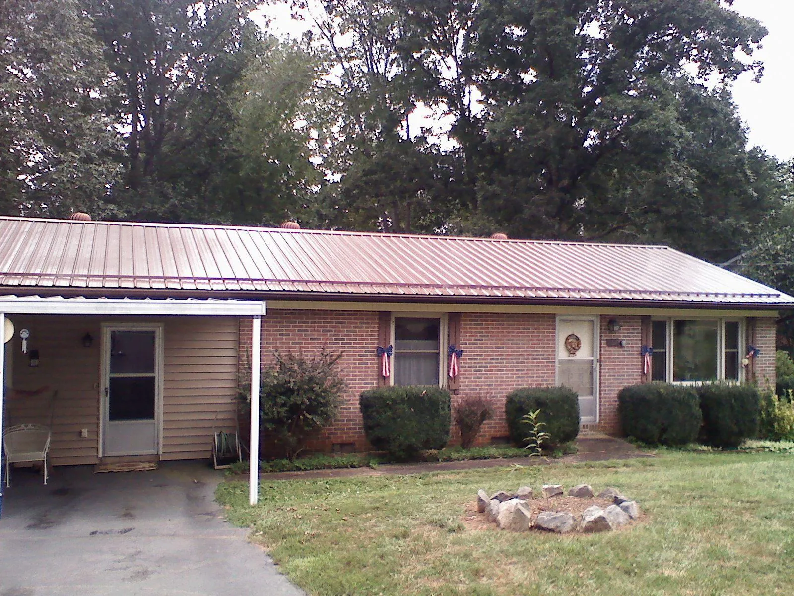 Bronze metal roof and carport on a brick ranch home — Roof Repair work by our crew in Maxatawny